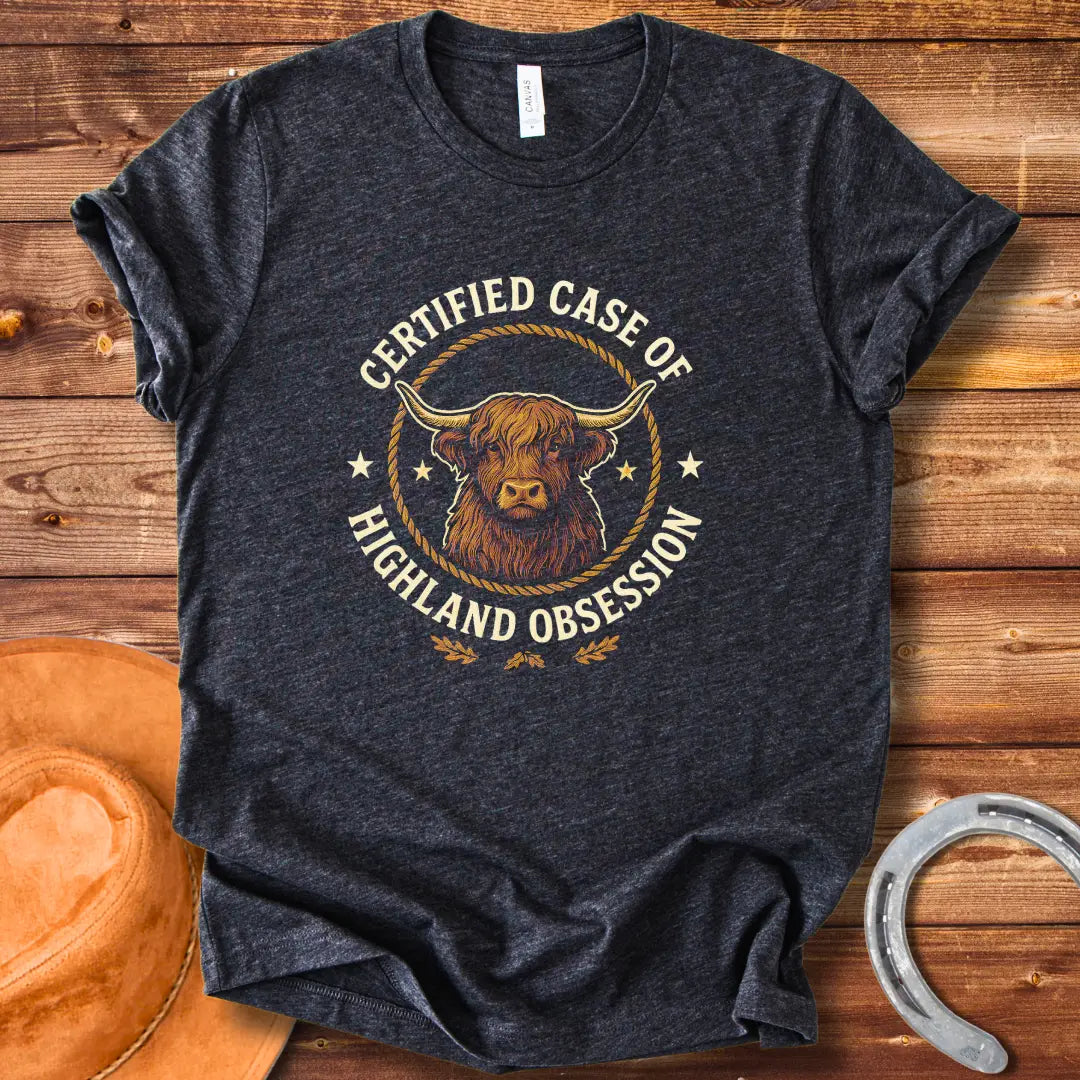 Certified Case of Highland Obsession T-Shirt featuring a detailed illustration of a Highland cow within a rope circle.