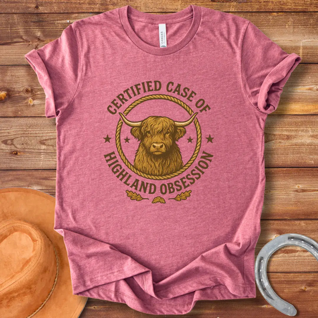 Certified Case of Highland Obsession T-Shirt featuring a detailed illustration of a Highland cow within a rope circle.