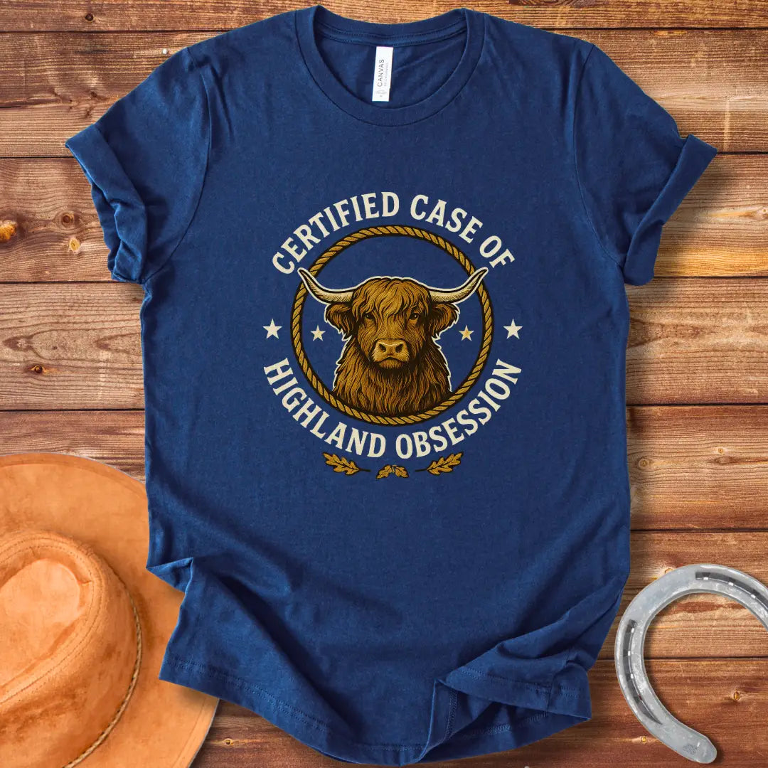 Certified Case of Highland Obsession T-Shirt featuring a detailed illustration of a Highland cow within a rope circle.