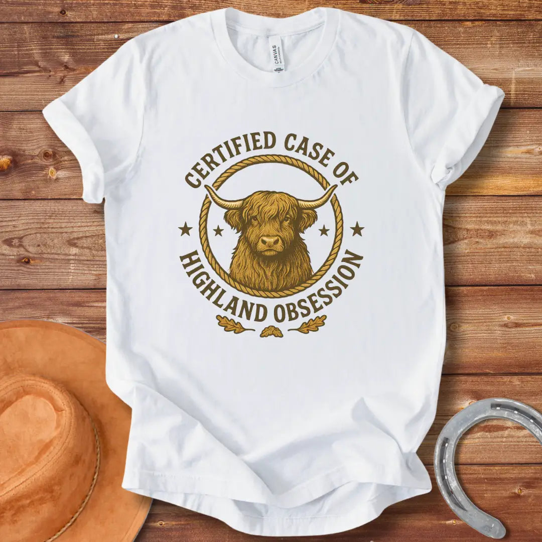 Certified Case of Highland Obsession T-Shirt featuring a detailed illustration of a Highland cow within a rope circle.