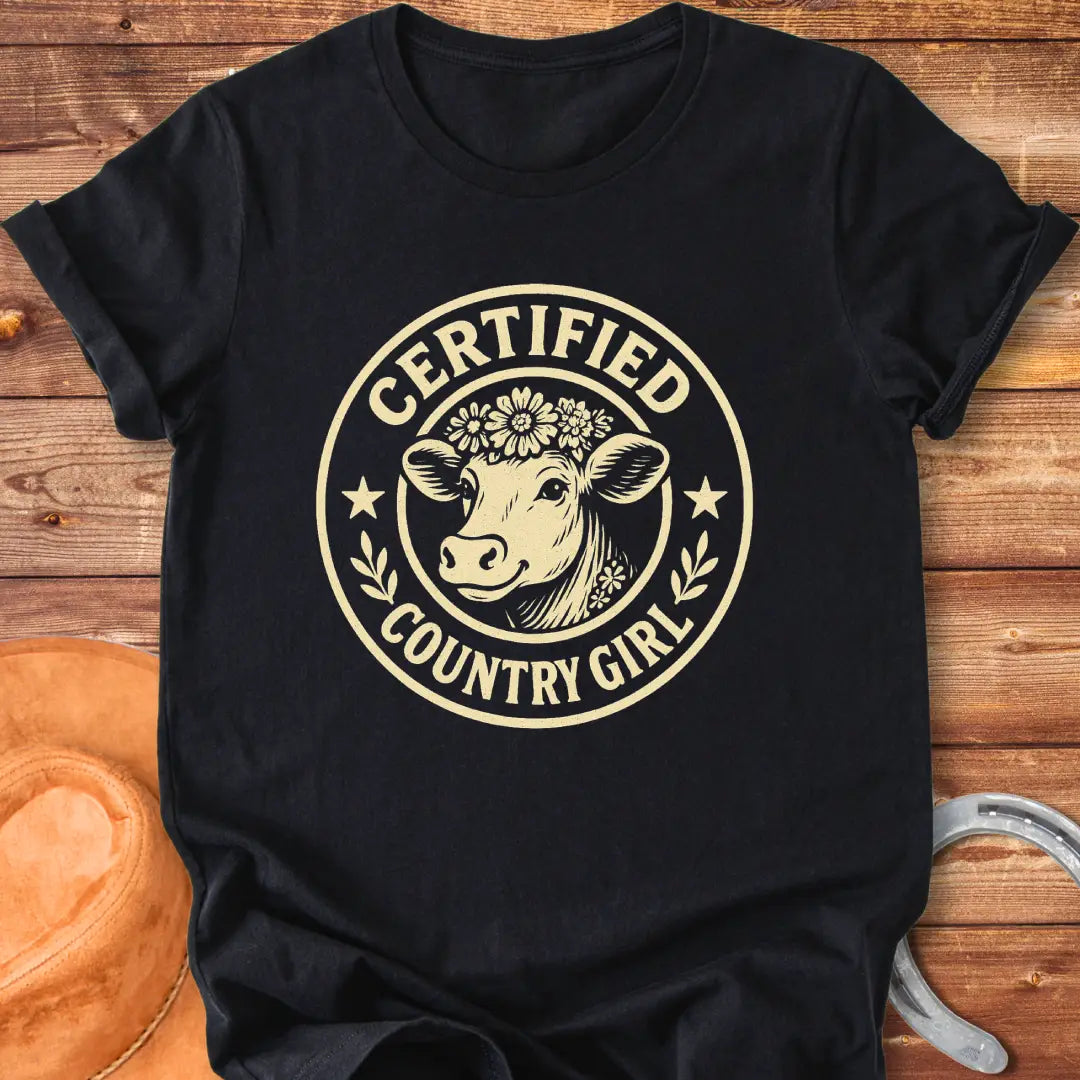 Certified Country Girl T-shirt featuring a cow with a floral crown inside a circular design.