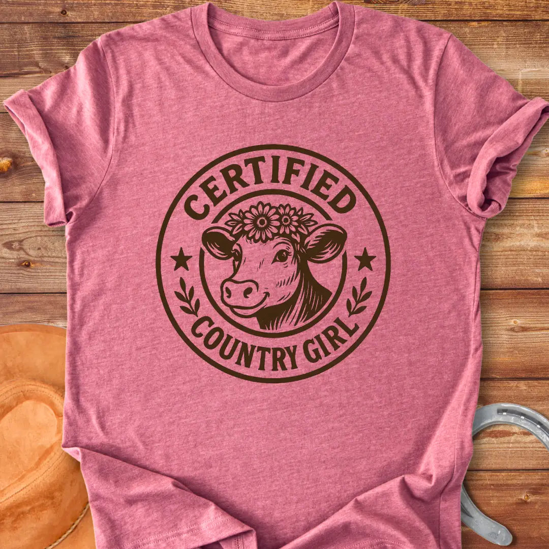 Certified Country Girl T-shirt featuring a cow with a floral crown inside a circular design.