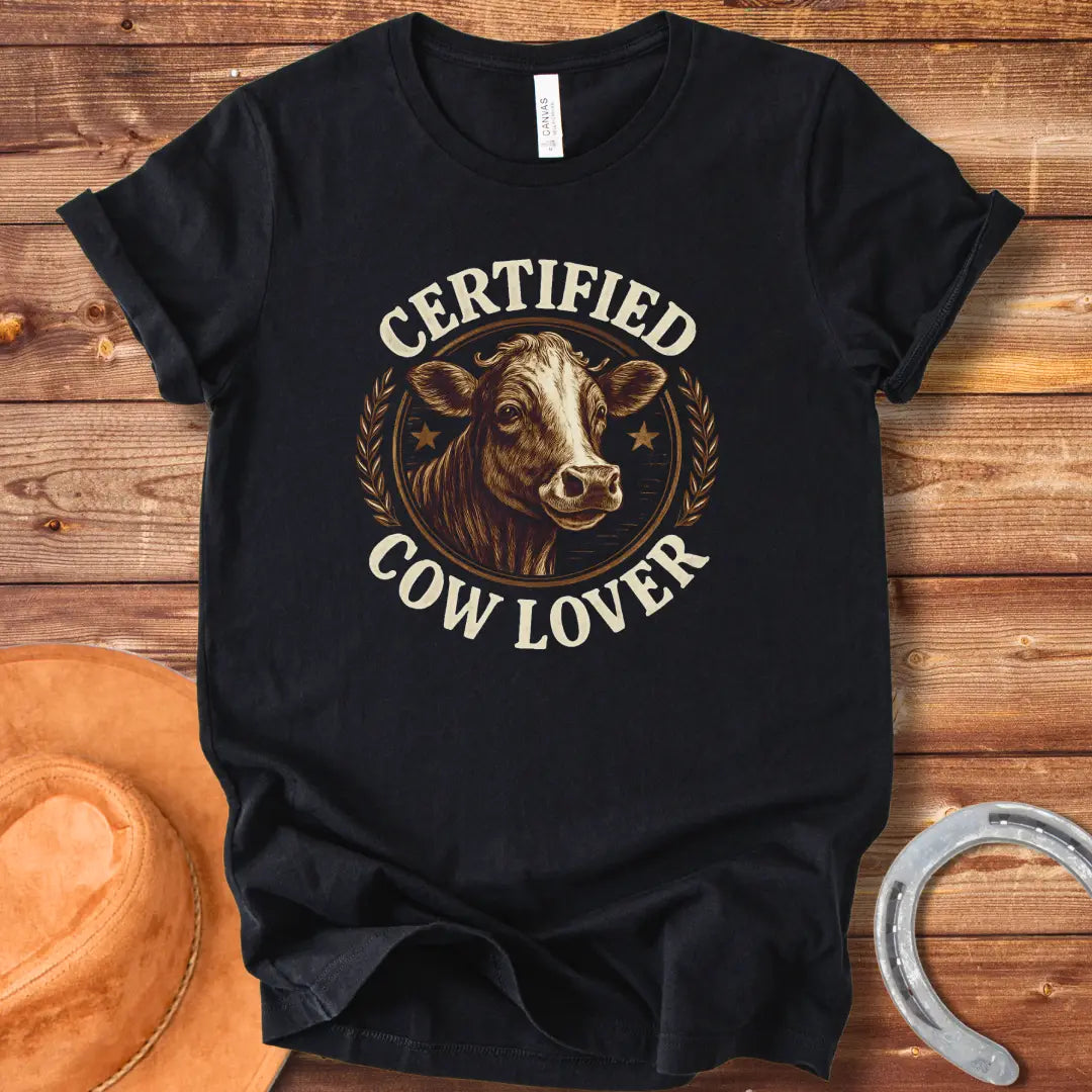 Certified Cow Lover T-shirt featuring a detailed illustration of a cow's face within a circular emblem with the text 'Certified Cow Lover'.