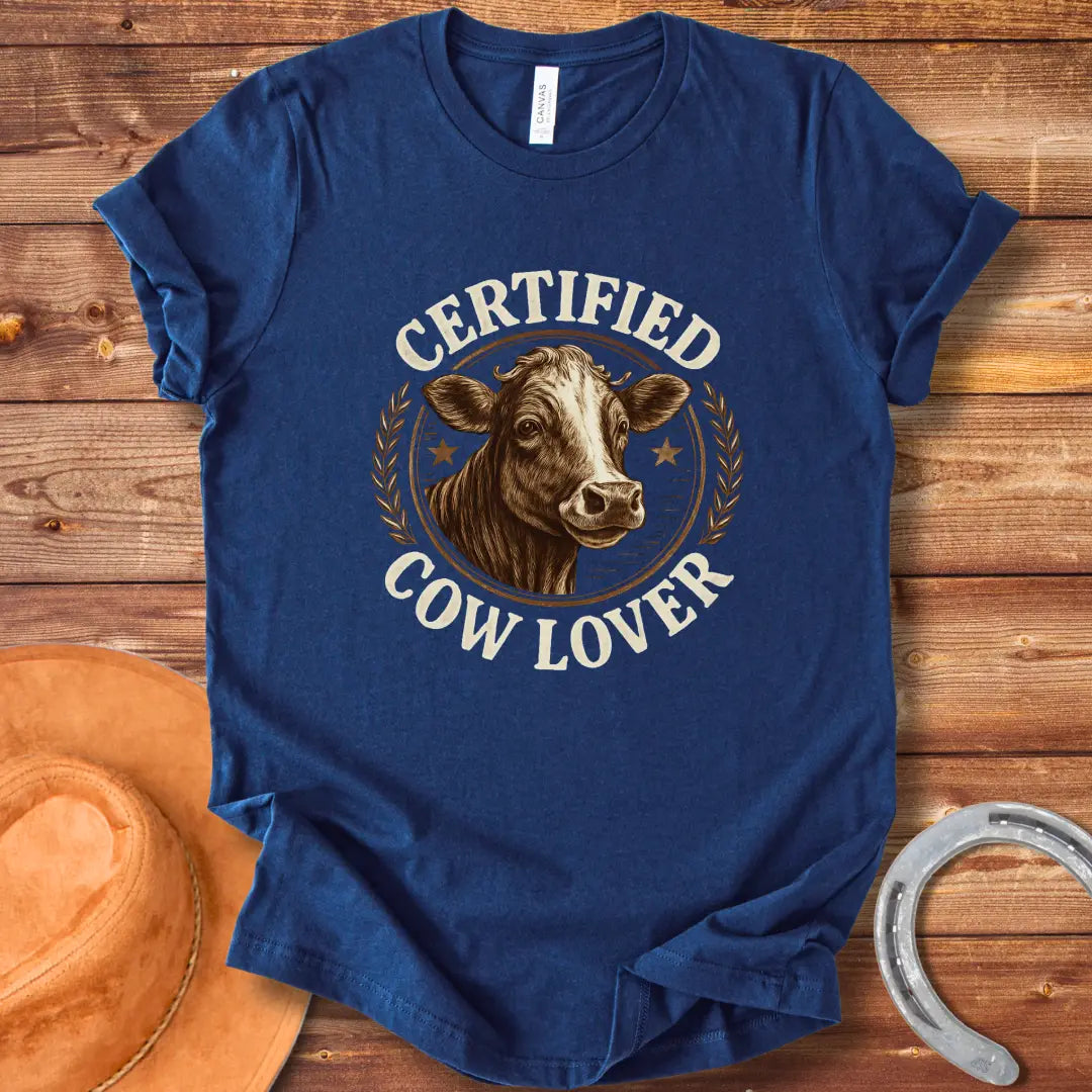 Certified Cow Lover T-shirt featuring a detailed illustration of a cow's face within a circular emblem with the text 'Certified Cow Lover'.