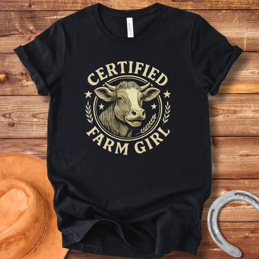 Certified Farm Girl T-Shirt design featuring a smiling cow's face inside a circular emblem with stars and wheat, perfect for cow lovers.