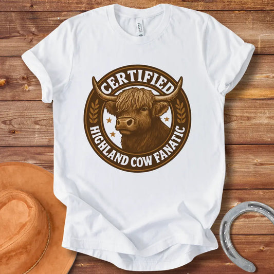 Certified Highland Cow Fanatic T-Shirt design, featuring a detailed illustration of a Highland cow within a circular badge with text.