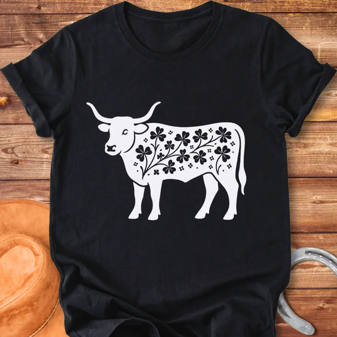 Black silhouette of a longhorn cow with clover patterns on its body