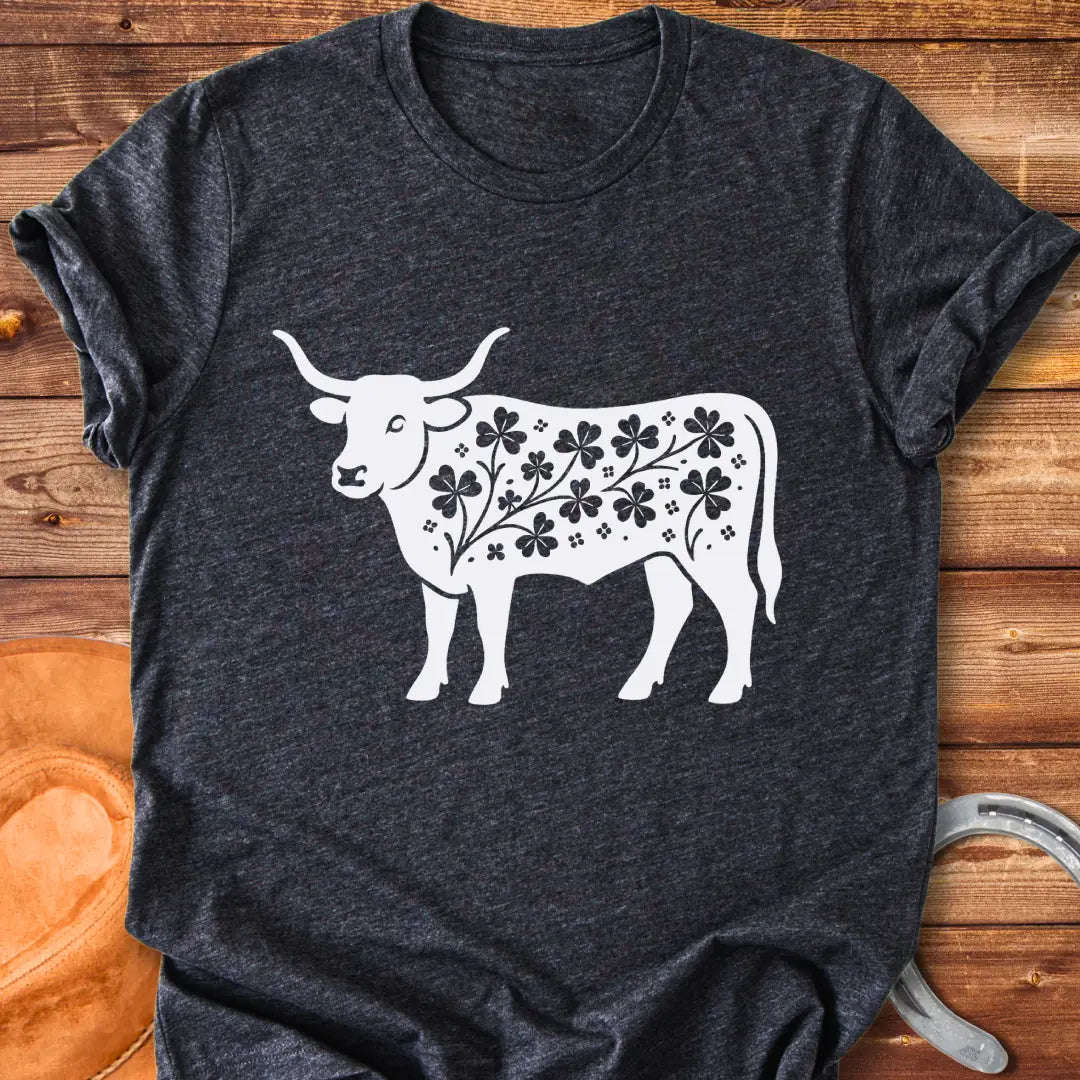 Black silhouette of a longhorn cow with clover patterns on its body