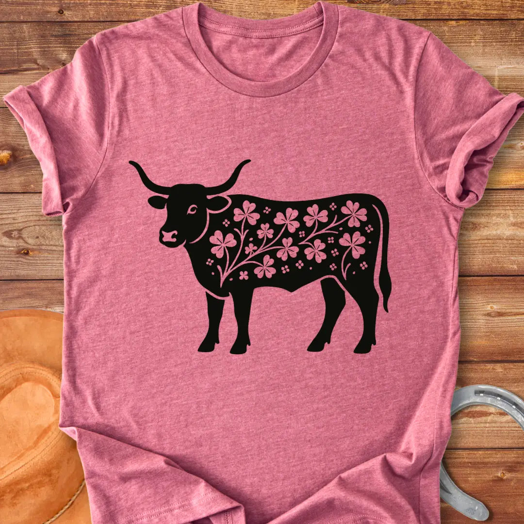 Black silhouette of a longhorn cow with clover patterns on its body