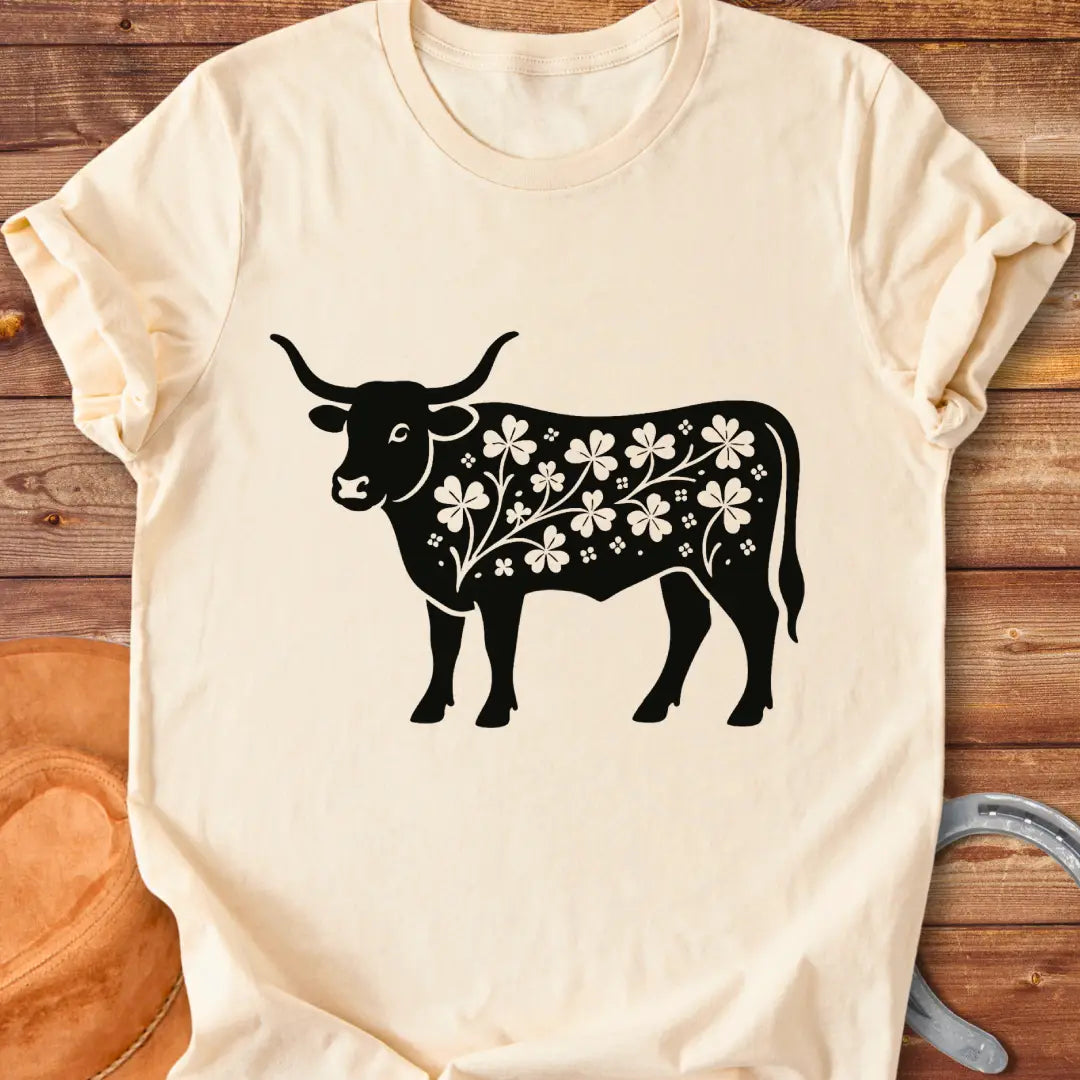 Black silhouette of a longhorn cow with clover patterns on its body