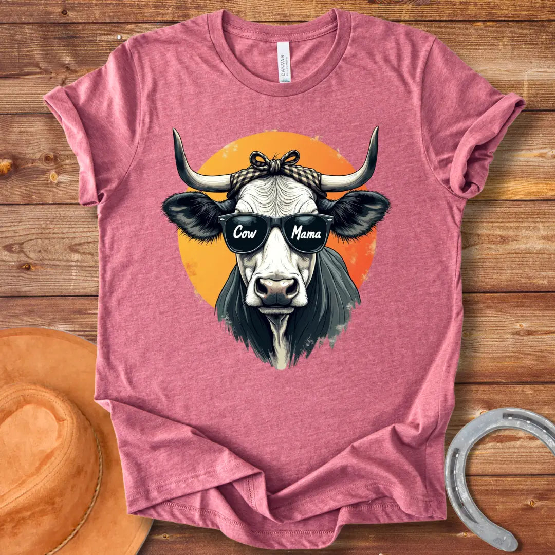 Cow Mama T-Shirt featuring a cool cow wearing sunglasses that say 'Cow Mama', against an orange sun.