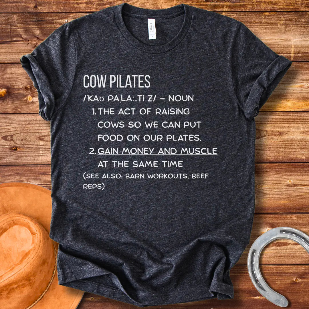 A stylish black t-shirt design featuring a cow doing pilates, against a black background.