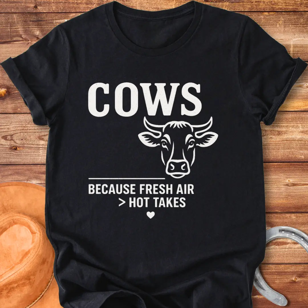Black and white t-shirt with a cow graphic and the text 'Cows Because Fresh Air Better Than Hot Takes.'
