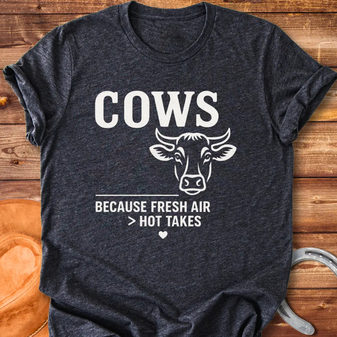 Black and white t-shirt with a cow graphic and the text 'Cows Because Fresh Air Better Than Hot Takes.'