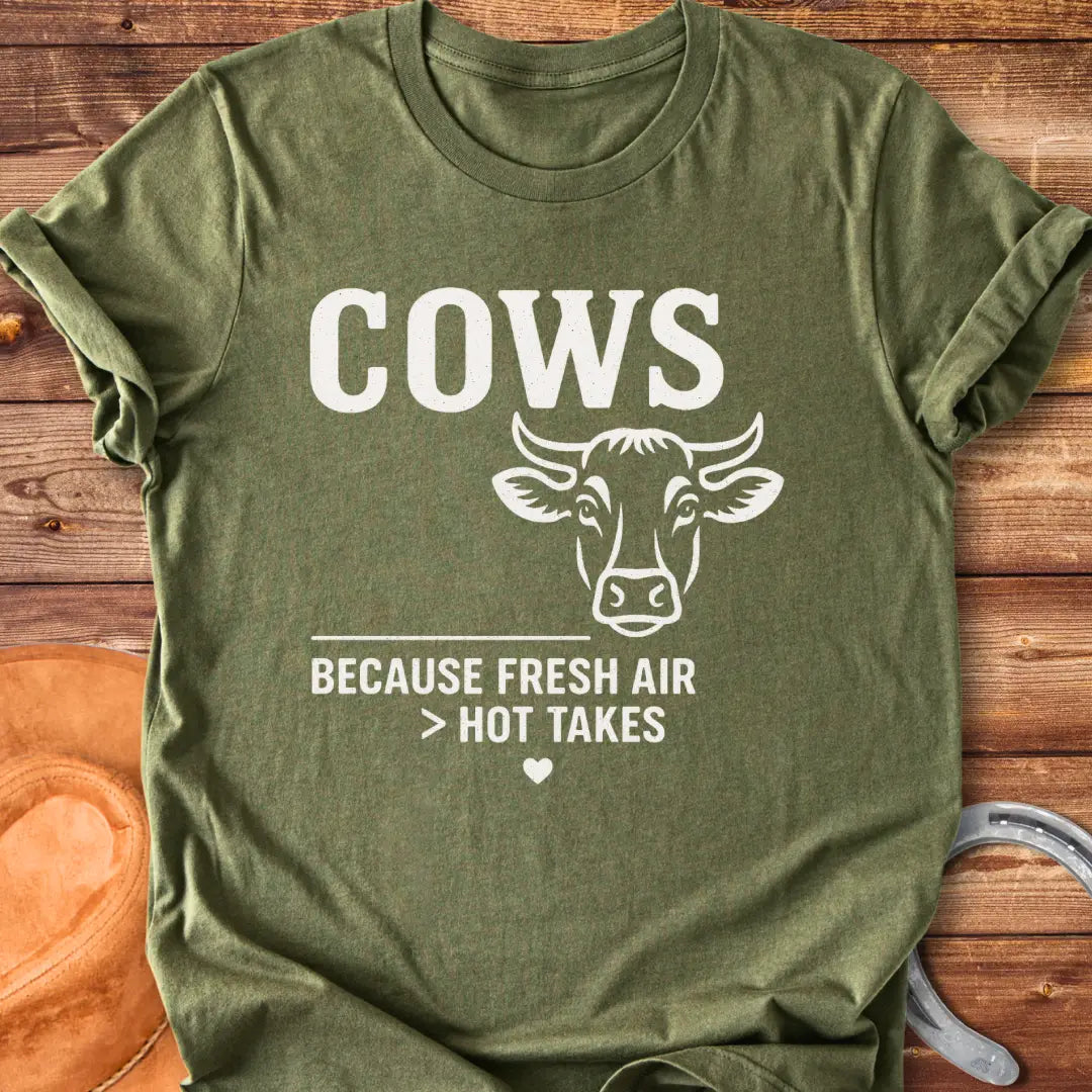 Black and white t-shirt with a cow graphic and the text 'Cows Because Fresh Air Better Than Hot Takes.'
