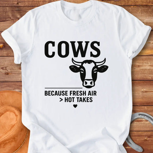 Black and white t-shirt with a cow graphic and the text 'Cows Because Fresh Air Better Than Hot Takes.'
