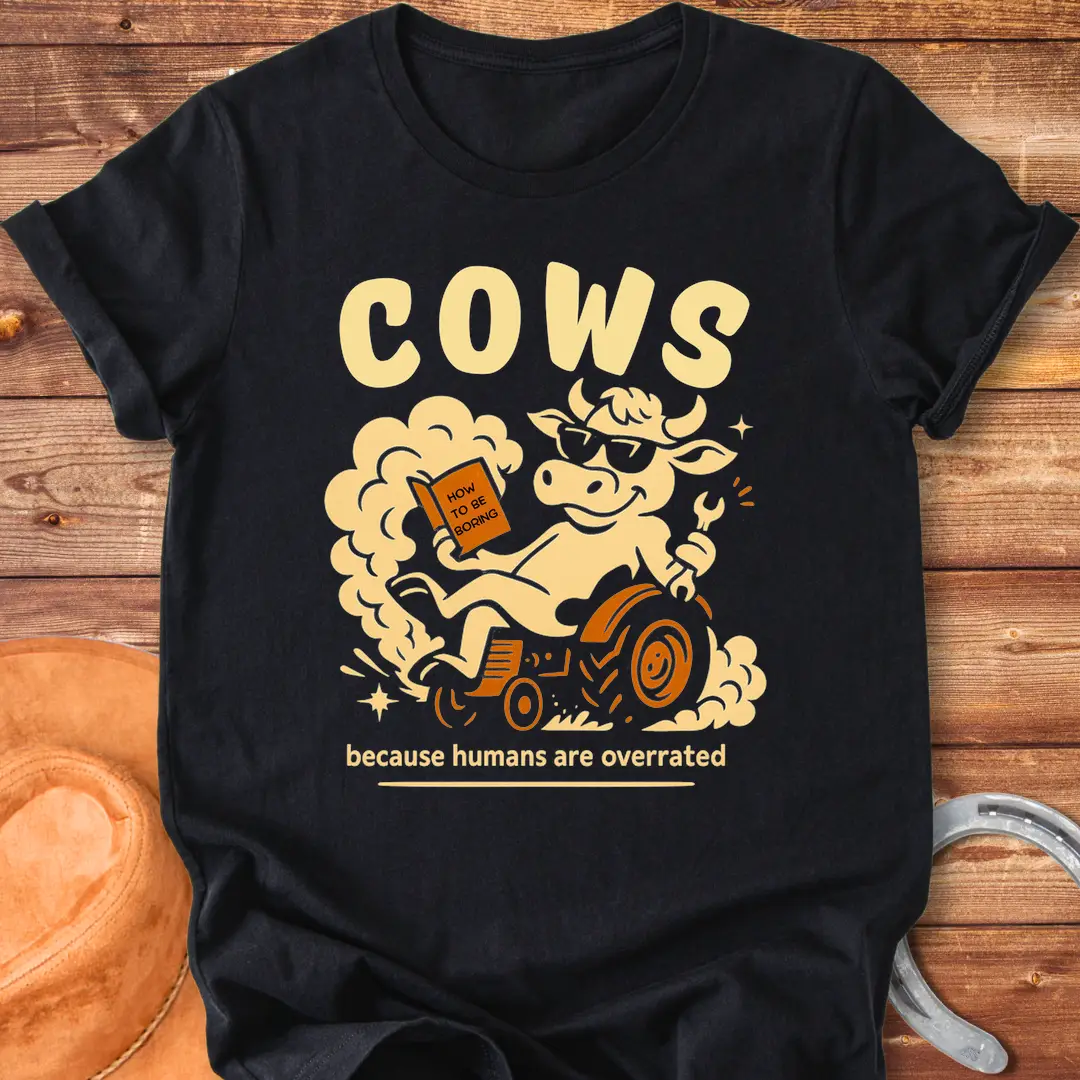 Funny t-shirt design featuring a cool cow reading a book on a tractor with the phrase 'Cows Because Humans Overrated'