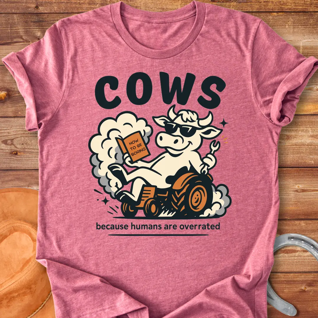 Funny t-shirt design featuring a cool cow reading a book on a tractor with the phrase 'Cows Because Humans Overrated'