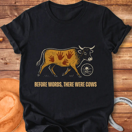 Vintage-style t-shirt design featuring a cow with handprints and the words "Before Words, There Were Cows."