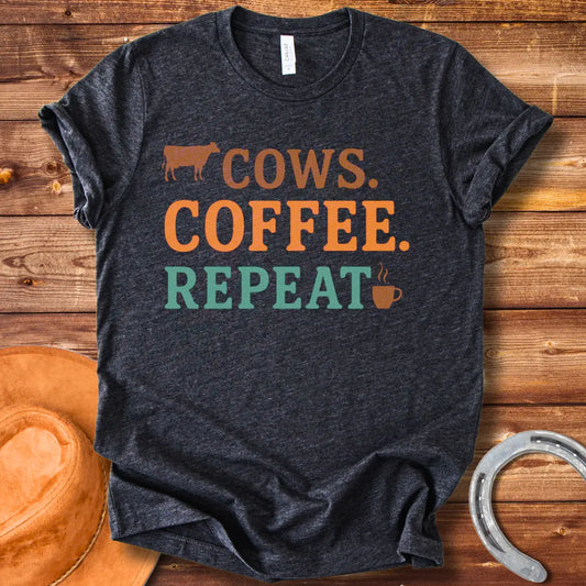Graphic design on a t-shirt showing a cow silhouette followed by the words 'COWS. COFFEE. REPEAT.' and a coffee cup icon.