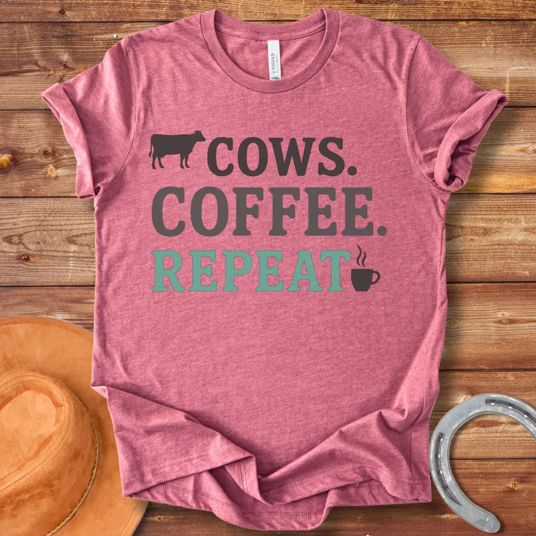 Graphic design on a t-shirt showing a cow silhouette followed by the words 'COWS. COFFEE. REPEAT.' and a coffee cup icon.