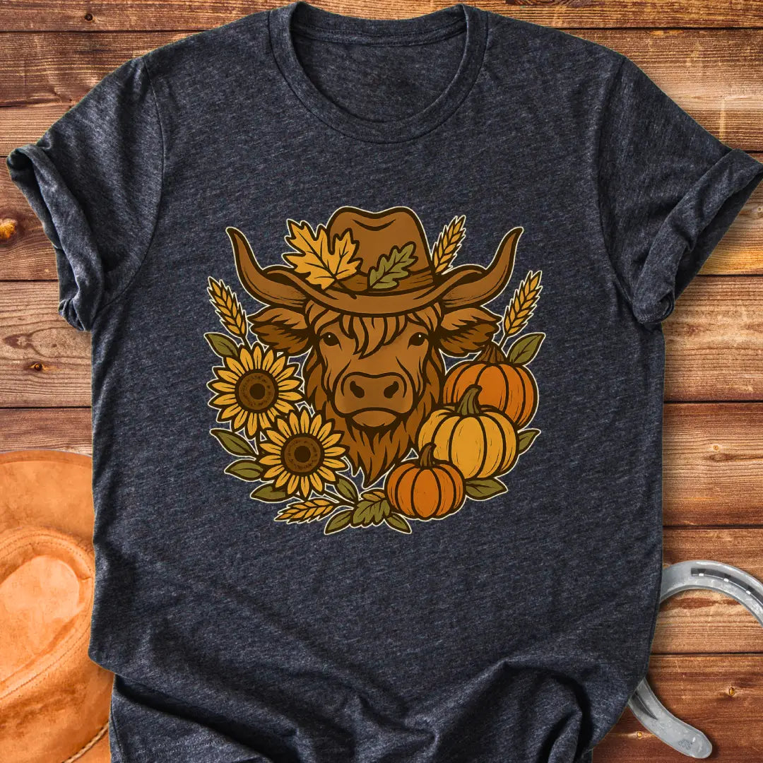 Farmhouse Fall T-Shirt featuring a Highland cow wearing a hat surrounded by sunflowers, pumpkins, and leaves