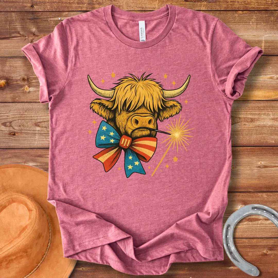 Festive patriotic Highland cow wearing a patriotic bow tie holding a sparkler.