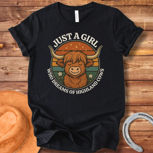 Girl Dreams of Highland Cows t-shirt with a cartoon illustration of a cute highland cow with the words "Just a girl who dreams of highland cows"