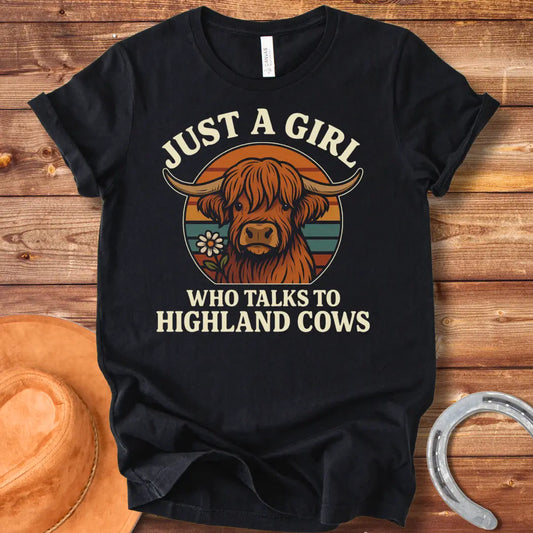 T-shirt featuring a cute Highland cow graphic with the text 'Just a Girl Who Talks to Highland Cows' and a flower.