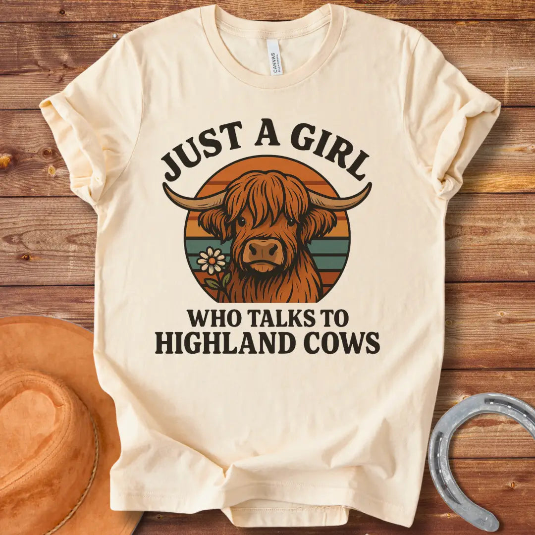T-shirt featuring a cute Highland cow graphic with the text 'Just a Girl Who Talks to Highland Cows' and a flower.