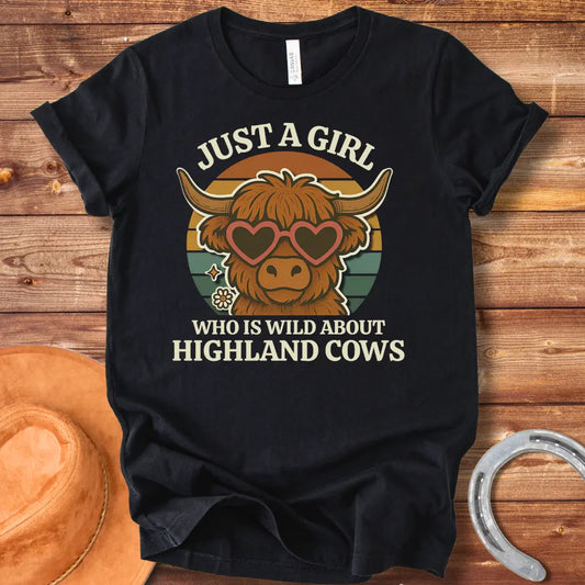 Girl Wild About Highland Cows t-shirt design featuring a Highland cow wearing heart-shaped sunglasses against a sunset backdrop.