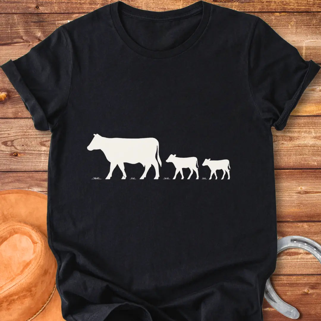 Silhouette of a cow family grazing, mother cow leading two calves