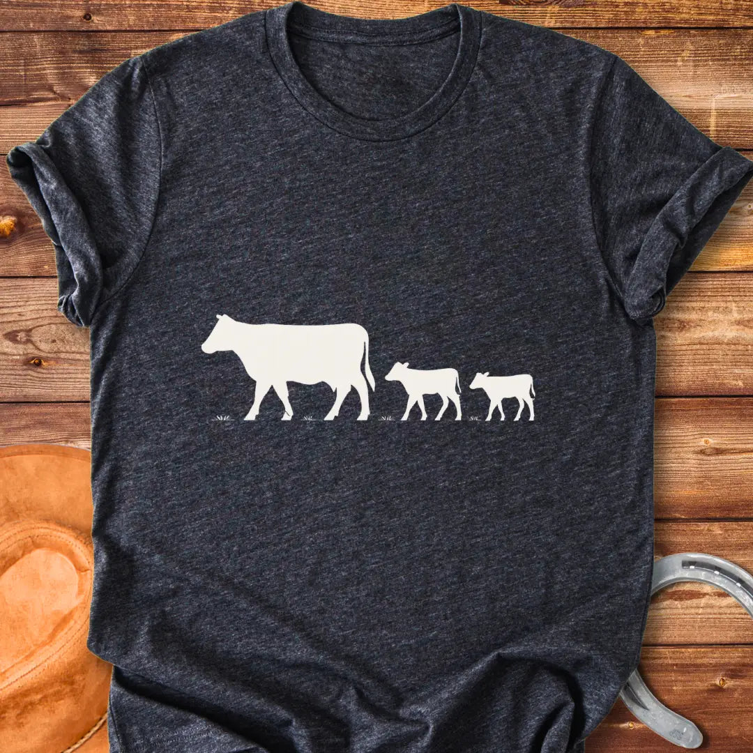 Silhouette of a cow family grazing, mother cow leading two calves