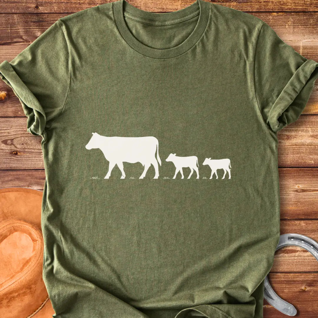 Silhouette of a cow family grazing, mother cow leading two calves