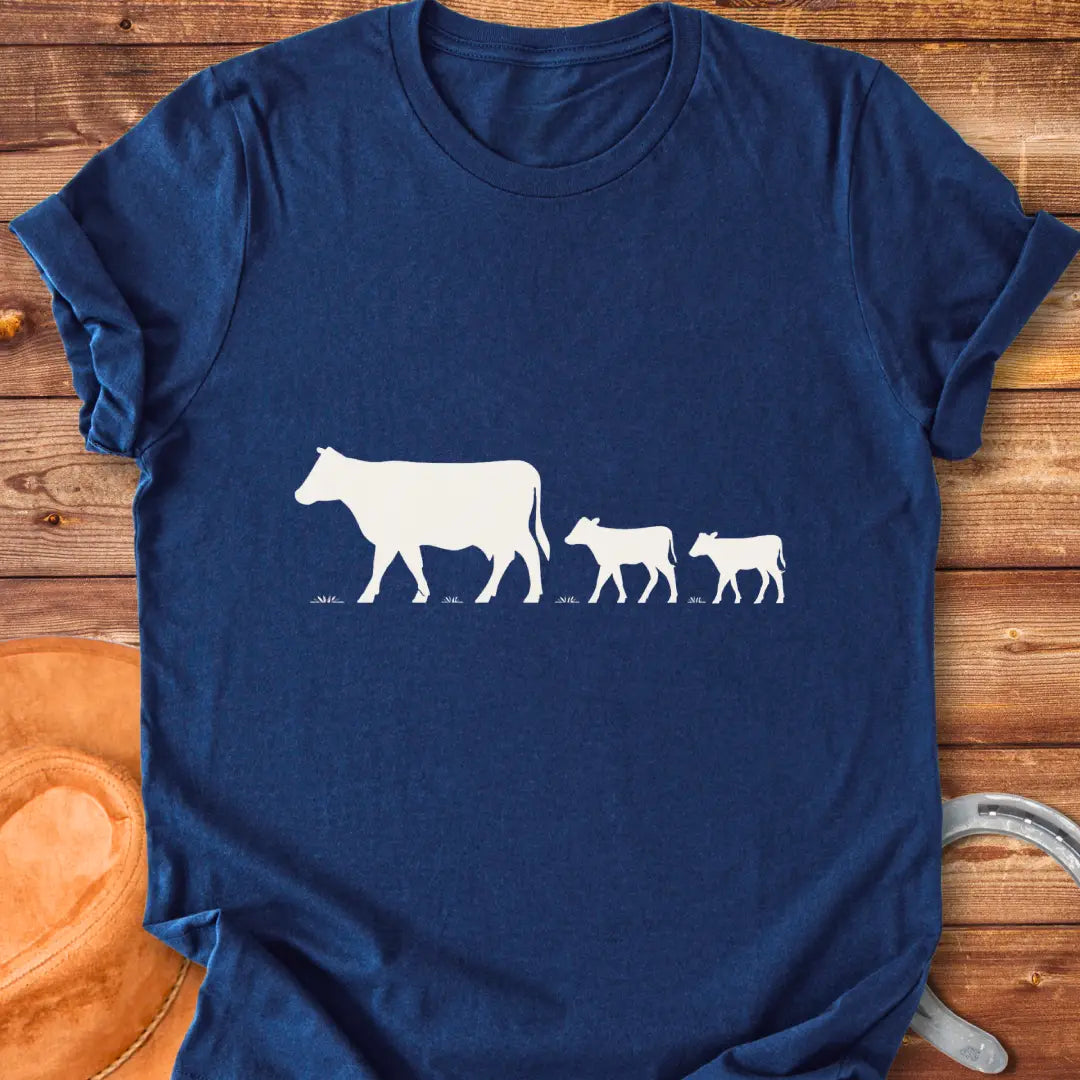 Silhouette of a cow family grazing, mother cow leading two calves
