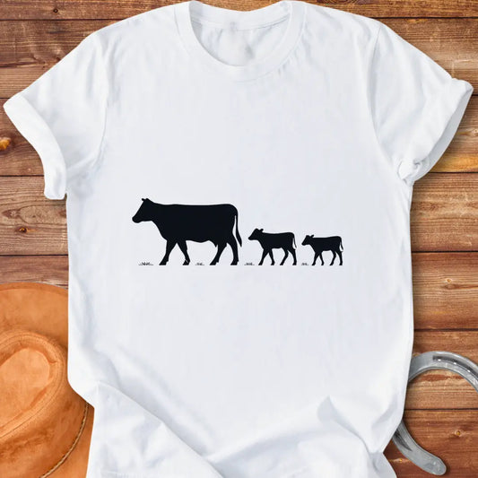 Silhouette of a cow family grazing, mother cow leading two calves
