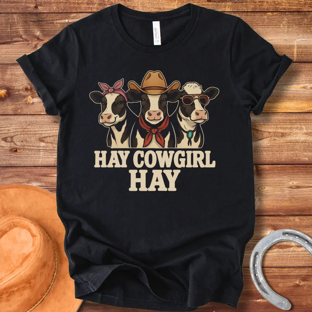 Three cartoon cows, one with a bandana, one with a cowboy hat and scarf, and one with sunglasses, with the text 'Hay Cow Girl Hay' below.