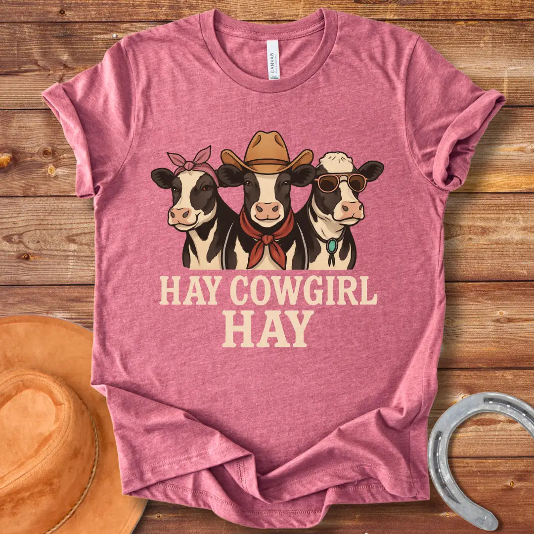 Three cartoon cows, one with a bandana, one with a cowboy hat and scarf, and one with sunglasses, with the text 'Hay Cow Girl Hay' below.