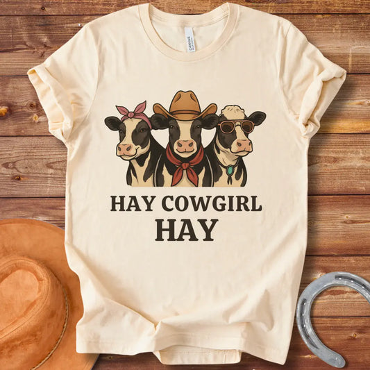 Three cartoon cows, one with a bandana, one with a cowboy hat and scarf, and one with sunglasses, with the text 'Hay Cow Girl Hay' below.