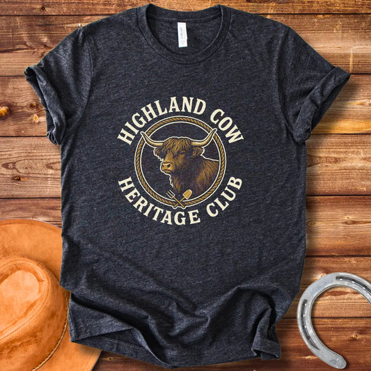 Highland Cow Heritage Club T-Shirt featuring a detailed illustration of a Highland cow with a rope circle and farm tools.