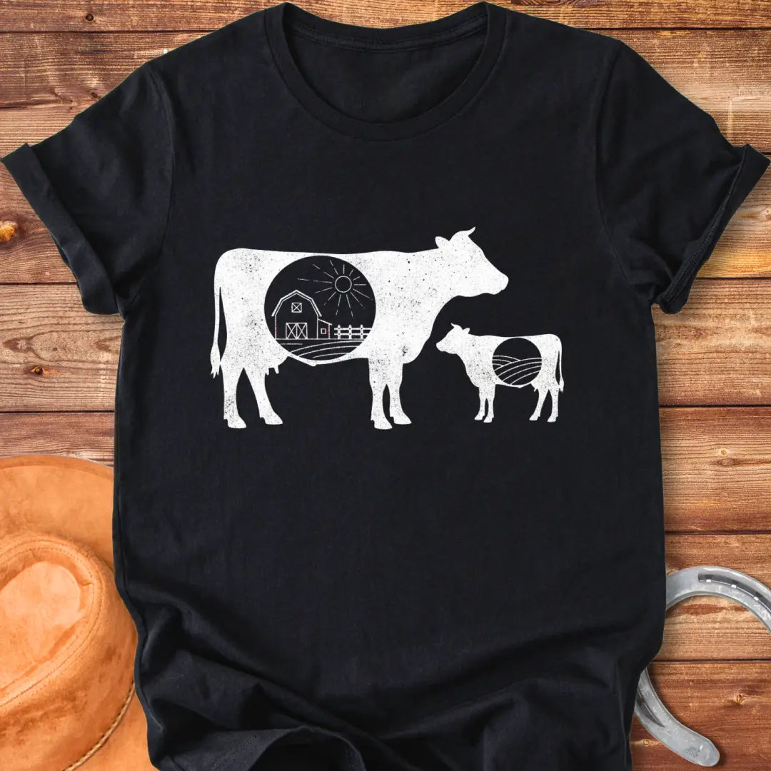 Silhouette of a mama cow and calf with a red barn in the middle, representing home and family