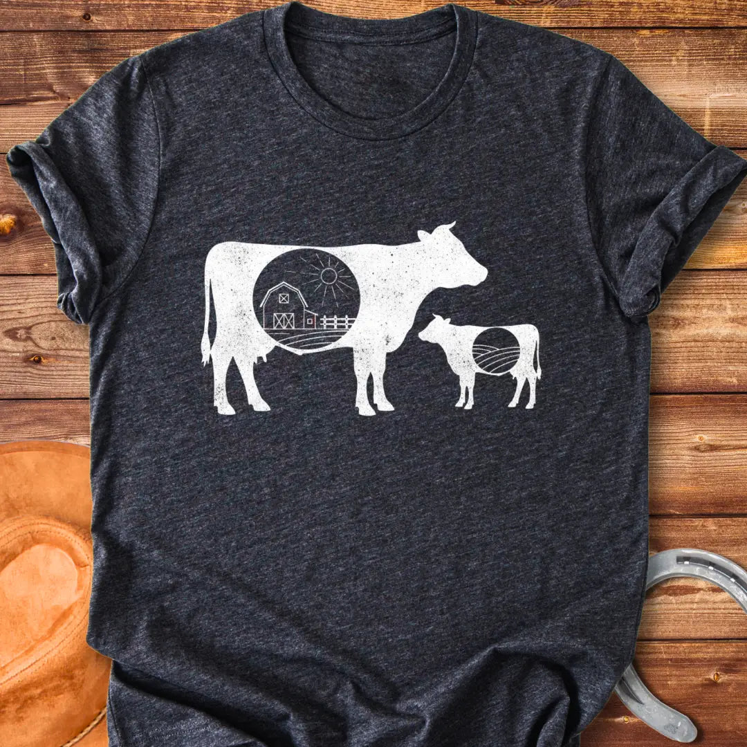 Silhouette of a mama cow and calf with a red barn in the middle, representing home and family