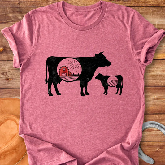 Silhouette of a mama cow and calf with a red barn in the middle, representing home and family
