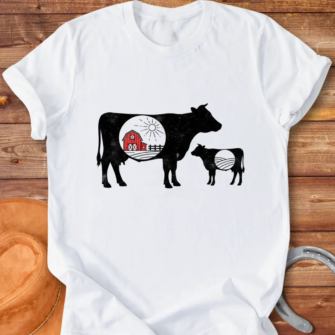 Silhouette of a mama cow and calf with a red barn in the middle, representing home and family