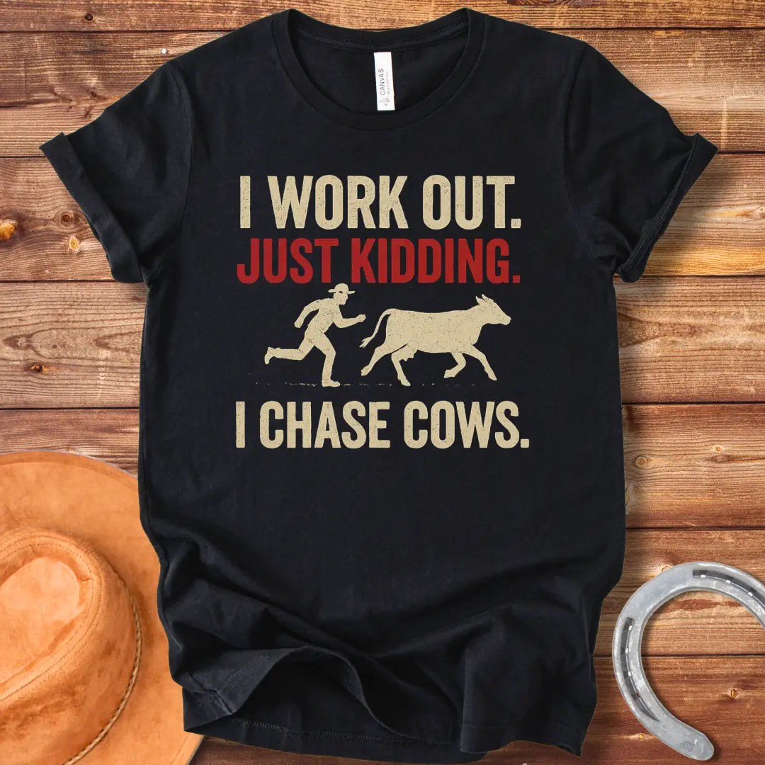 Vintage T-shirt with a humorous design of a person chasing a cow, with the words 'I Work Out. Just Kidding. I Chase Cows.'