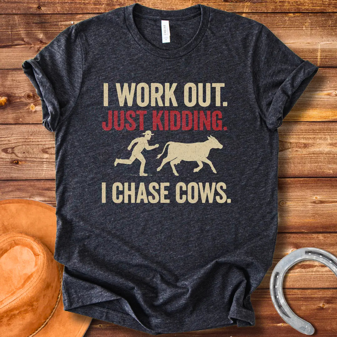 Vintage T-shirt with a humorous design of a person chasing a cow, with the words 'I Work Out. Just Kidding. I Chase Cows.'