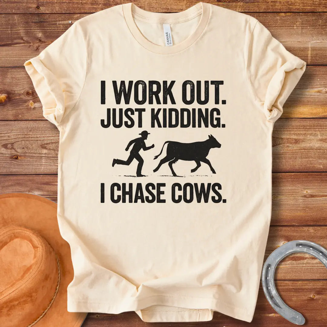 Vintage T-shirt with a humorous design of a person chasing a cow, with the words 'I Work Out. Just Kidding. I Chase Cows.'