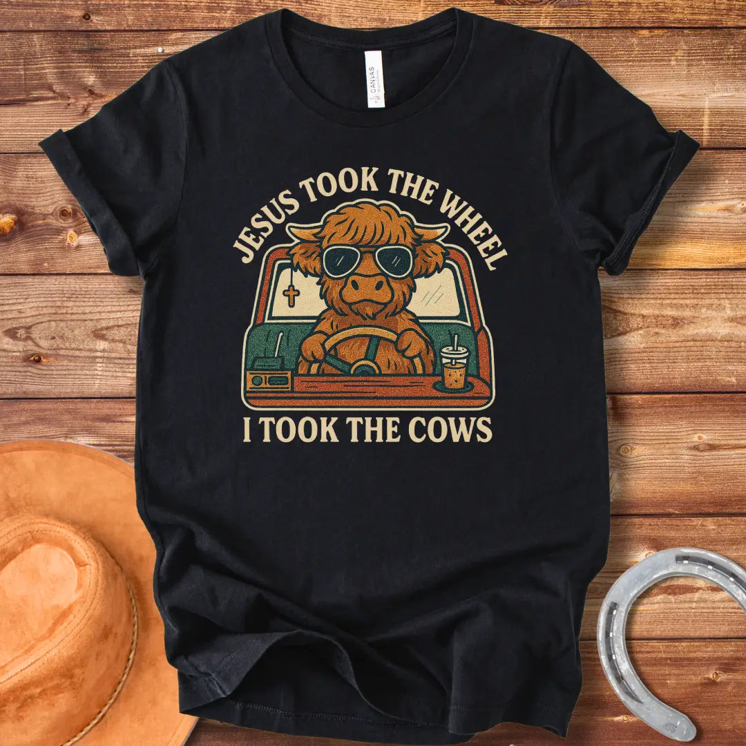 A Highland cow wearing sunglasses drives a car while holding a coffee; text reads 'Jesus took the wheel, I took the cows'.