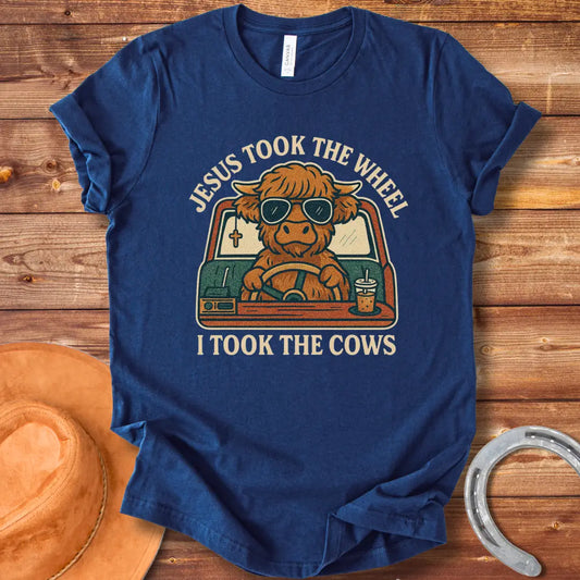 A Highland cow wearing sunglasses drives a car while holding a coffee; text reads 'Jesus took the wheel, I took the cows'.