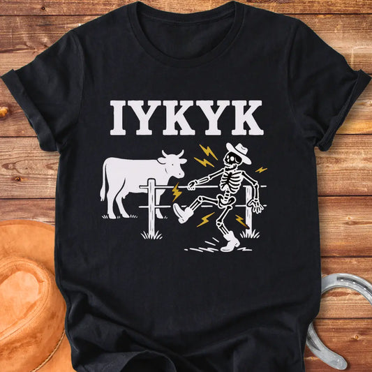 Funny graphic tee featuring a skeleton getting shocked by an electric fence with a cow in the background.